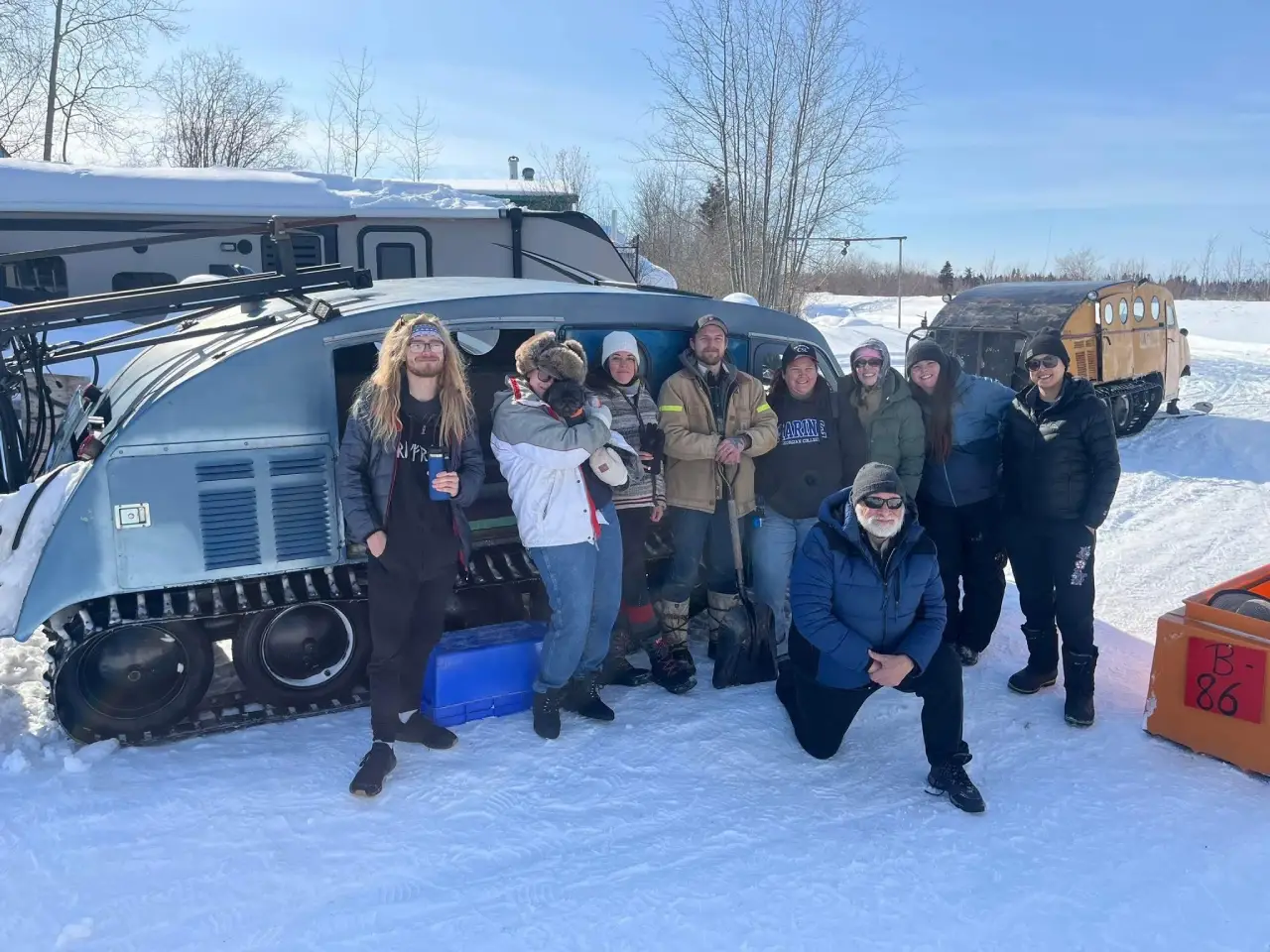 WAMTC students with a snow vehicle in the snow